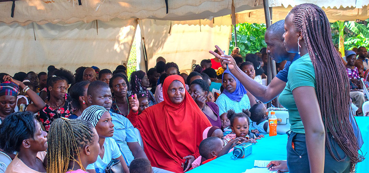 A Field Researcher addresses participants at the 2024 EMaBS participant meeting held at the Entebbe General Hospital, Uganda, engaging them in discussions about the study’s progress and upcoming research activities.